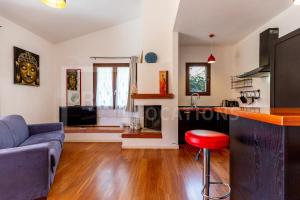Il comprend un salon avec un canapé bleu et une cuisine. dans l'établissement Appartamento Baia Azzurra - BeLocations, à Capitana