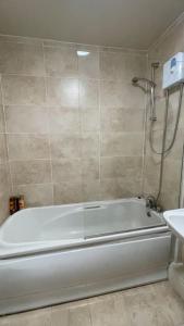 a white bath tub in a bathroom with a shower at City Gem - Central & Stylish 1 Bed Apartment in Dublin
