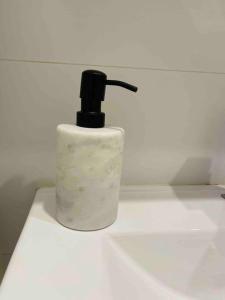 a soap dispenser sitting on top of a sink at Stylish Apartment with city view close to beach airport cbd in Sydney