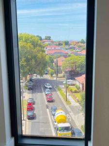 a view from a window of a street with cars at Stylish Apartment with city view close to beach airport cbd in Sydney