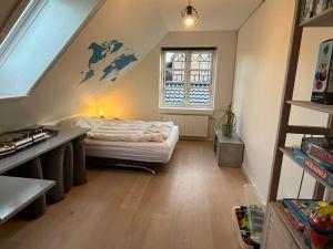 HøjbjergにあるNyere villa nær by, skov, strandのベッドと窓が備わる屋根裏部屋