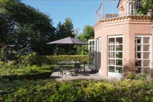 un patio con mesa y sombrilla en Nyere villa nær by, skov, strand, en Højbjerg