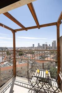 a balcony with a table and chairs and a view of a city at City Lights 4 BR Stunning Apart in Jerusalem