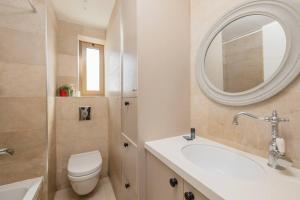 ein Badezimmer mit einem WC, einem Waschbecken und einem Spiegel in der Unterkunft City Lights 4 BR Stunning Apart in Jerusalem