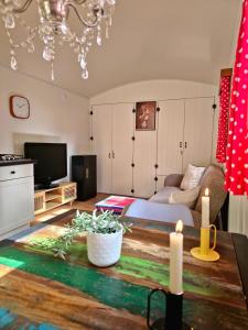 ein Wohnzimmer mit einem Sofa und einem TV in der Unterkunft pipowagen met prive Hot tub in Lanaken
