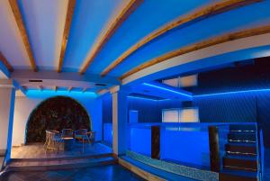 a room with blue lighting and tables and chairs at Prince of Lake Hotel in Shkodër
