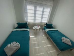 two beds in a small room with a table at Appartement des 3 pays. 2 mn de Bâle+ Free parking in Saint-Louis