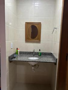ドミンゴス・マルチンスにあるChalé Essência do Valeの洗面台と鏡のあるバスルーム +17枚の写真