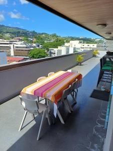 roof top Papeete في بابيت: طاولة وكراسي على شرفة مطلة