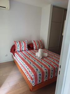 roof top Papeete في بابيت: غرفة نوم مع سرير مع لحاف ووسائد ملونة