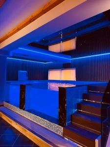 um quarto com luzes azuis nas escadas em Prince of Lake Hotel em Shkodër