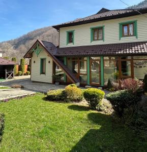 a house with a yard with green grass at Apartments Mandry in Yaremche