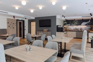 a restaurant with tables and chairs and a flat screen tv at I'M INN Zwettl - Hotel zum Brauhaus in Zwettl Stadt