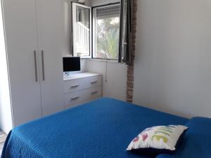 a bedroom with a blue bed and a window at Bellavista in Torre dell'Orso