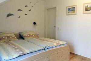 łóżko w pokoju z ptakami na ścianie w obiekcie NEU! Ferienwohnung Arkona auf Rügen w mieście Putgarten