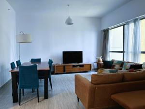 sala de estar con sofá, mesa y TV en Dubai Town Jumeirah Beach Residence en Dubái