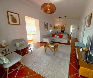 een woonkamer met een bank en een tafel bij Casa do Terraço in São Martinho do Porto
