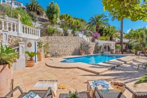 a villa with a swimming pool and palm trees at Villa Domingo - PlusHolidays in Benissa