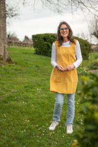 een vrouw in een gele jurk die in het gras staat bij Domaine Beaumont in Distré