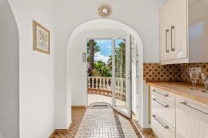 a kitchen with an archway leading to a balcony at Villa Domingo - PlusHolidays in Benissa