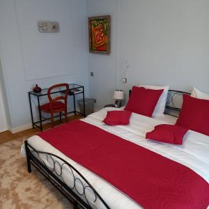 a bedroom with a large bed with red pillows at Molibeau in Beauvais