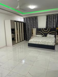 um quarto com uma cama e luz verde em VEGAS APERTMENT em Amdalai