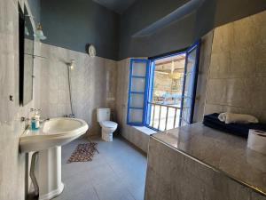 baño con lavabo y aseo y ventana en chez youssef, en Fez