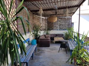 chez youssef في فاس: فناء مع أريكة وطاولات ونباتات