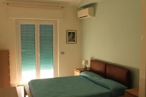 ローマにあるLuminoso guest houseのベッドルーム(緑のベッド1台、窓付)