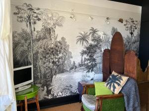 una camera con una parete decorata con un murale di palme di OYO Cornerstone Manor Hotel a Sale
