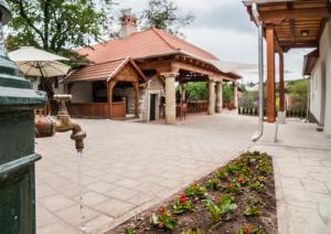 a pavilion with a fountain and flowers in a garden at Zsirai Guest House in Mád