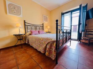 Un dormitorio con una cama con almohadas rosas. en Puerta del Agua, en Uclés
