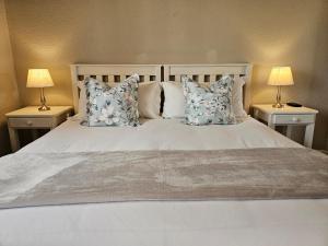 sypialnia z białym łóżkiem z poduszkami i 2 lampami w obiekcie Aloes 1st on Camp w mieście Middelburg