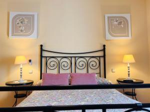 1 dormitorio con 1 cama con almohadas moradas y 2 lámparas en Puerta del Agua, en Uclés