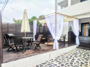 a patio with a table and chairs and an umbrella at L'Escale in Saint-Pierre