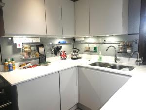 a kitchen with white cabinets and a sink at escape the ordinary - private self catered holiday home stay in Dorchester