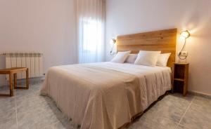 um quarto com uma cama grande e uma cabeceira em madeira em FONTETA em Fonteta