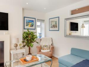 a living room with a blue couch and a chair at The Studio in Beckington