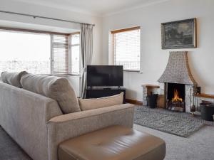 a living room with a couch and a fireplace at Lyncroft Holiday Bungalow in Sandbach
