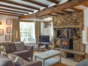a living room with a stone fireplace and a tv at Brow House in Brigsteer