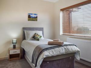 a bedroom with a bed with a window and a bed sidx sidx sidx at Lyncroft Holiday Bungalow in Sandbach