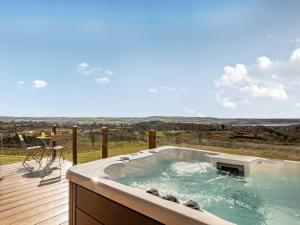 una bañera de hidromasaje en una terraza con vistas en Oakwood Lodge, en Lochwinnoch