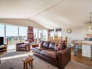 uma sala de estar com um sofá e uma mesa em Oakwood Lodge em Lochwinnoch