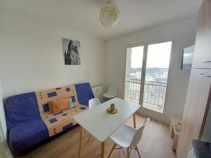 een slaapkamer met een bed en een tafel en stoelen bij Appartement 28m2 proche gare SNCF+café+thé+WIFI gratuits in Orléans