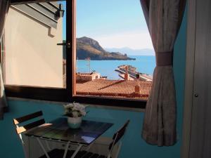 a table with a view of the ocean from a window at B&B Margherita in Marina di Camerota