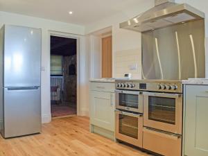 een keuken met een fornuis en een koelkast bij Merrow Cottage in Ledbury