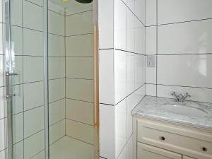 een witte badkamer met een wastafel en een douche bij Merrow Cottage in Ledbury