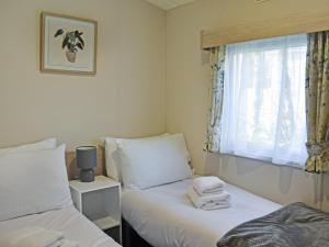 a bedroom with two beds and a window with towels at Saffron in Banchory