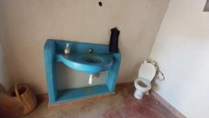 a blue sink in a bathroom with a toilet at Riad Auberge Bassou in Nkob