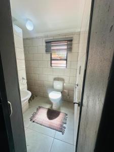 uma pequena casa de banho com um WC e uma janela em the curve apartment unit 27 em Joanesburgo